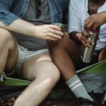 User-Friendly Experience - Diverse friends having rest in tent with tea in thermos